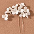 White three dimensional flower u shaped hairpin with white ceramic petals and clear crystal centers with twisted metal pins