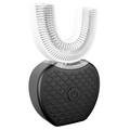 White ultrasonic electric toothbrush with u-shaped brush head and black textured charging base with power button for automatic tooth cleaning