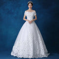 White off-the-shoulder wedding gown with intricate lace detailing and beaded embellishments for bridal wear