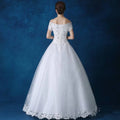 White off-the-shoulder wedding gown with lace detailing beaded embellishments and a full tulle skirt for bridal wear