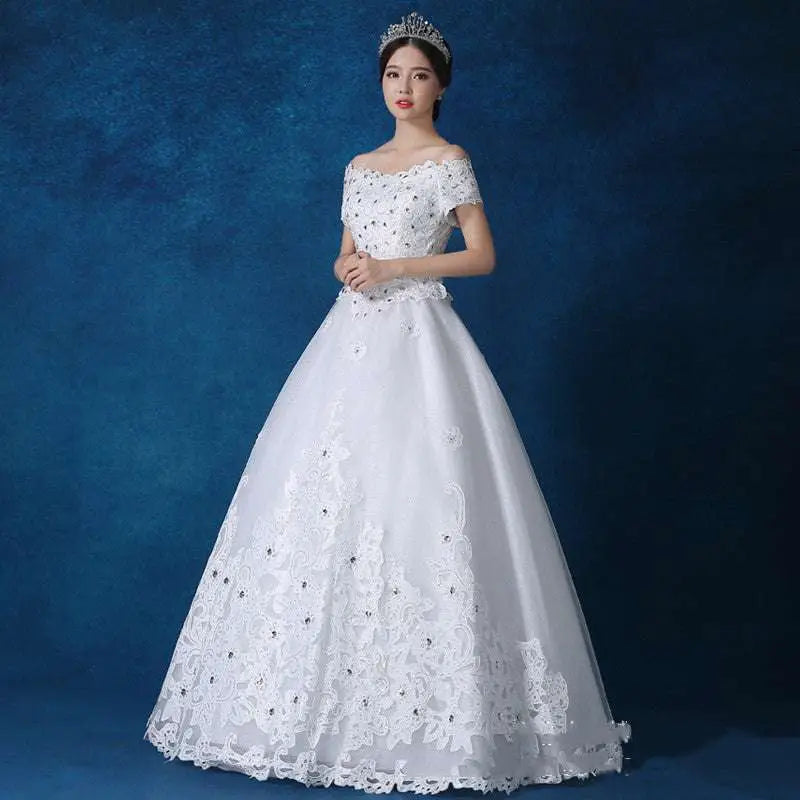 White off-the-shoulder wedding gown with intricate lace detailing and beaded embellishments for bridal wear