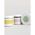 Three glass jars of wholesale natural body scrub set with white lids and yellow pink green minimalist labels display natural ingredients