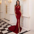 A sleek wine red annual meeting dress featuring a one shoulder solid color mermaid silhouette with a high slit