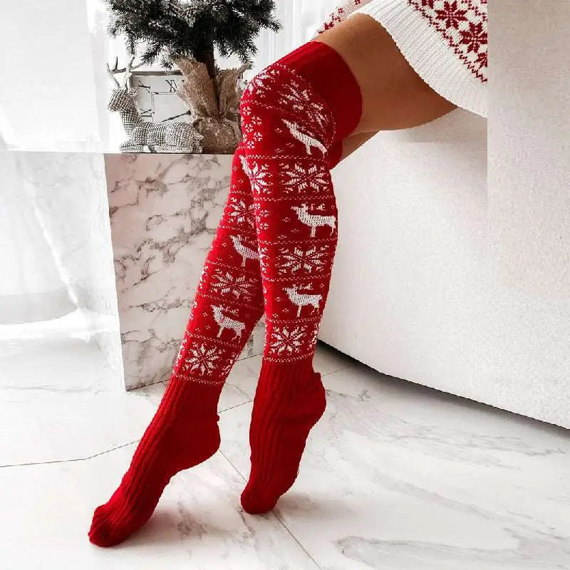 Red knitted christmas thigh-high stockings with white reindeer and snowflake patterns for winter christmas warm dress