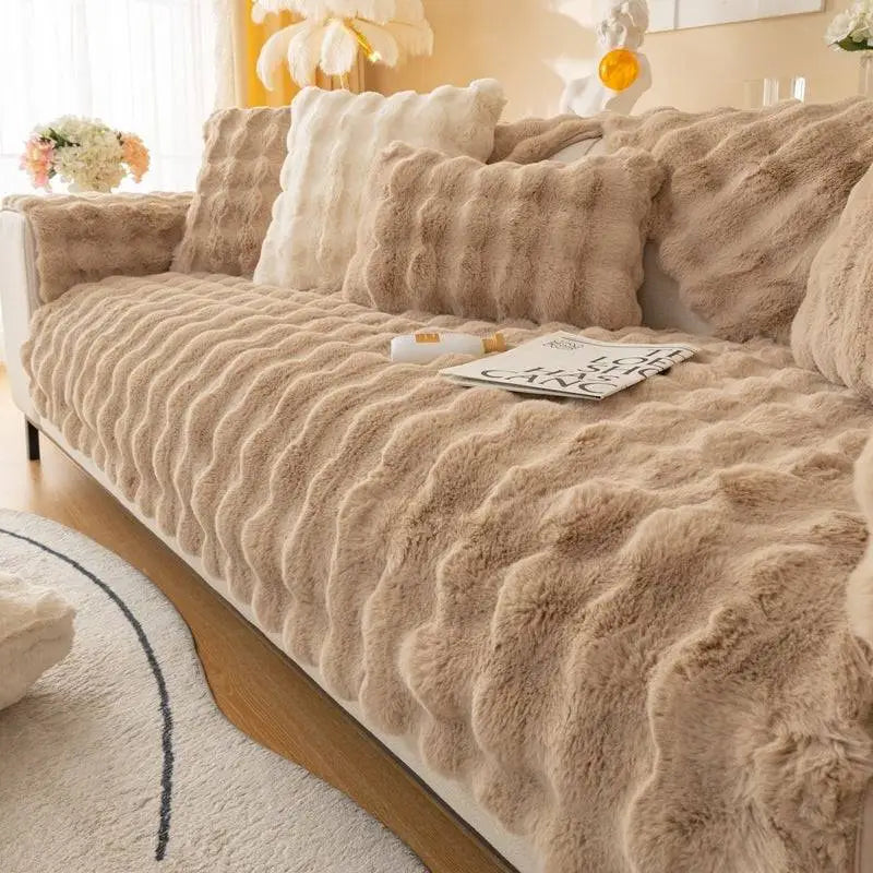 Beige faux fur sofa cover with a thickened rabbit plush texture and matching pillows for winter comfort
