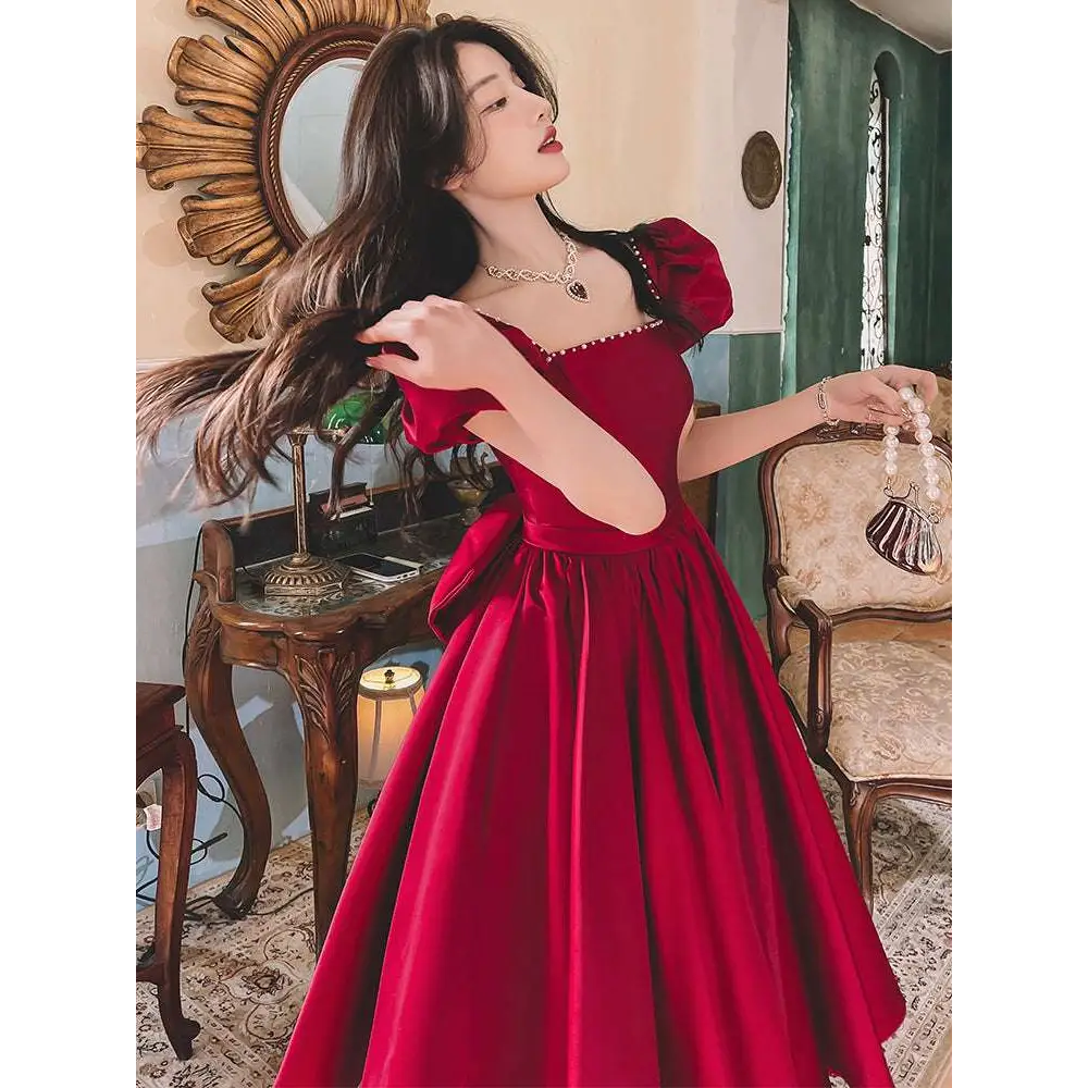 A winter wine red satin engagement dress with puffed sleeves square neckline and pearl embellishments on fitted bodice