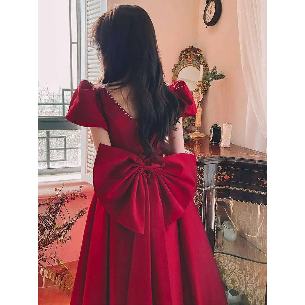 Winter wine red satin engagement dress with puffed sleeves, square neckline, and large elegant back bow shown from the back