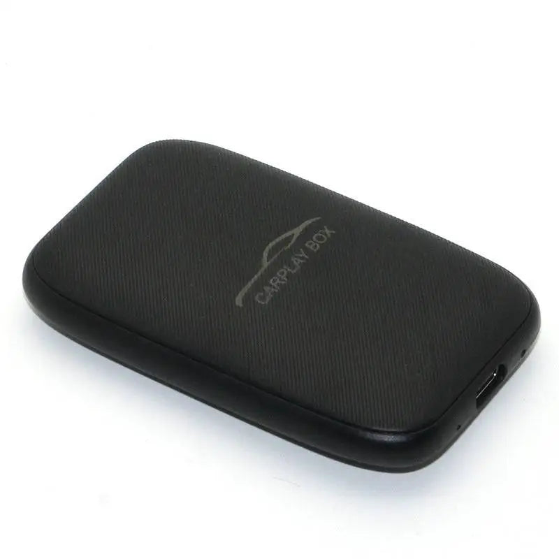 Black textured rectangular wireless carplay box device with silver logo and usb port for original car integration