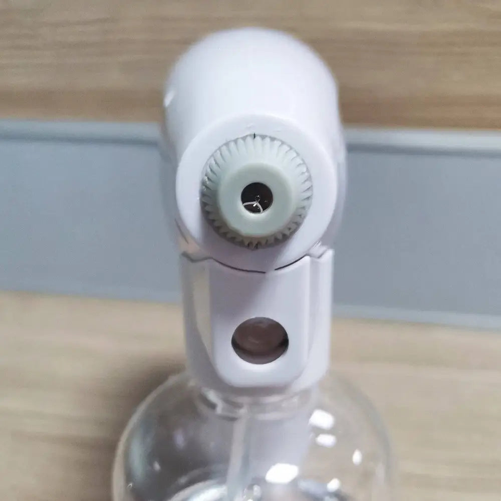 White wireless electric sprayer disinfection gun with blue light and clear liquid reservoir attached to plastic bottle