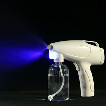 White wireless electric sprayer disinfection gun with blue light and clear liquid reservoir attached to plastic bottle