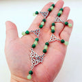 A delicate witchcraft Irish knot jade pagan headpiece with alternating dark and light green jade beads and silver celtic charms