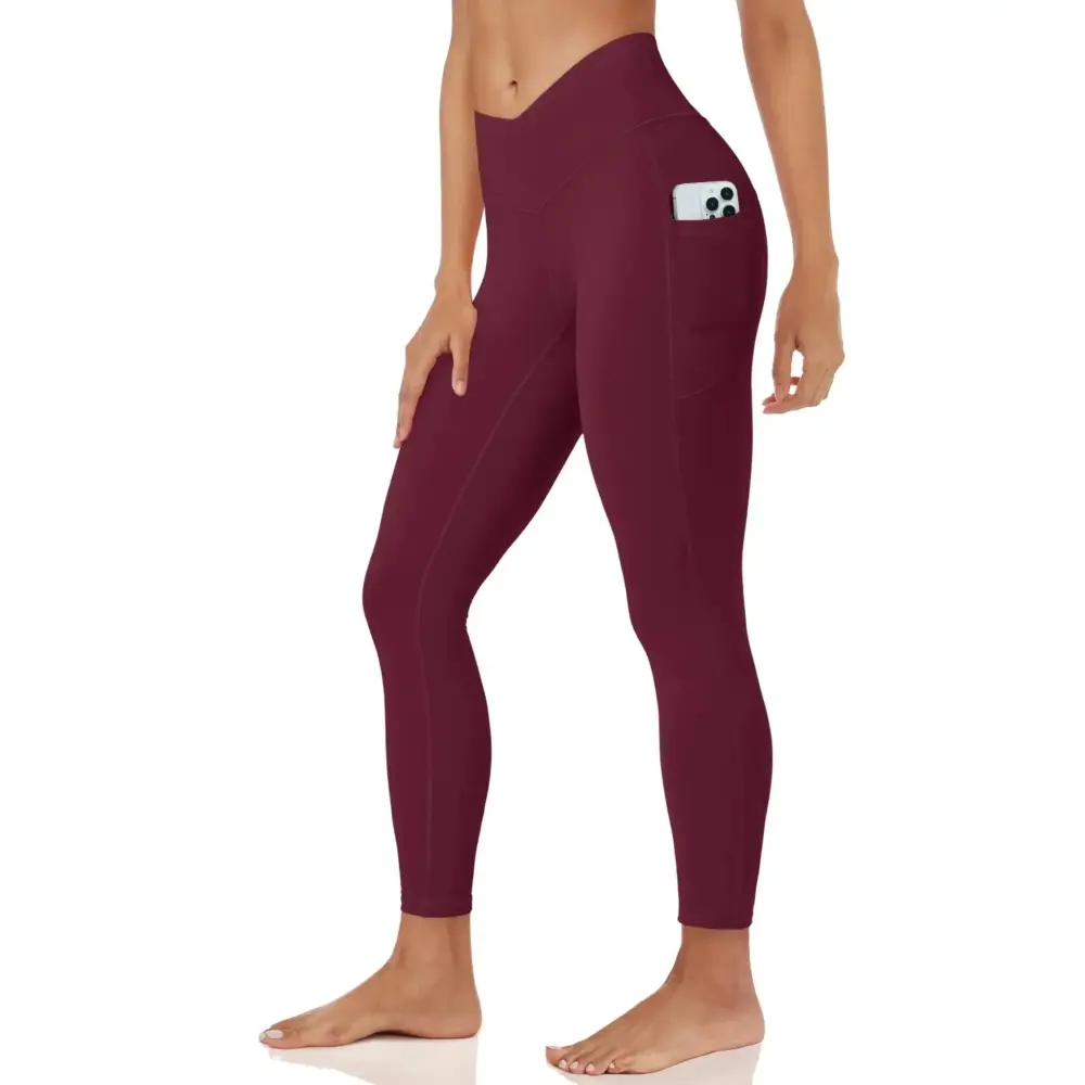 Maroon women high waisted leggings with brushed lining featuring a side pocket holding a smartphone