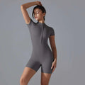 A sleek dark gray shorts jumpsuit yoga bodysuit with short sleeves and a front zipper designed for summer