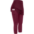 Women tennis skirted leggings in maroon with a high-waisted design and skirted leggings pockets holding a smartphone