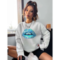 Women’s long sleeve sweatshirt in white featuring a vibrant blue lips graphic with iridescent green accents on the front