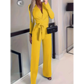 Bright yellow long-sleeved wrap jumpsuit with belted waist and wide-leg pants offers a flattering fit silhouette and is machine washable