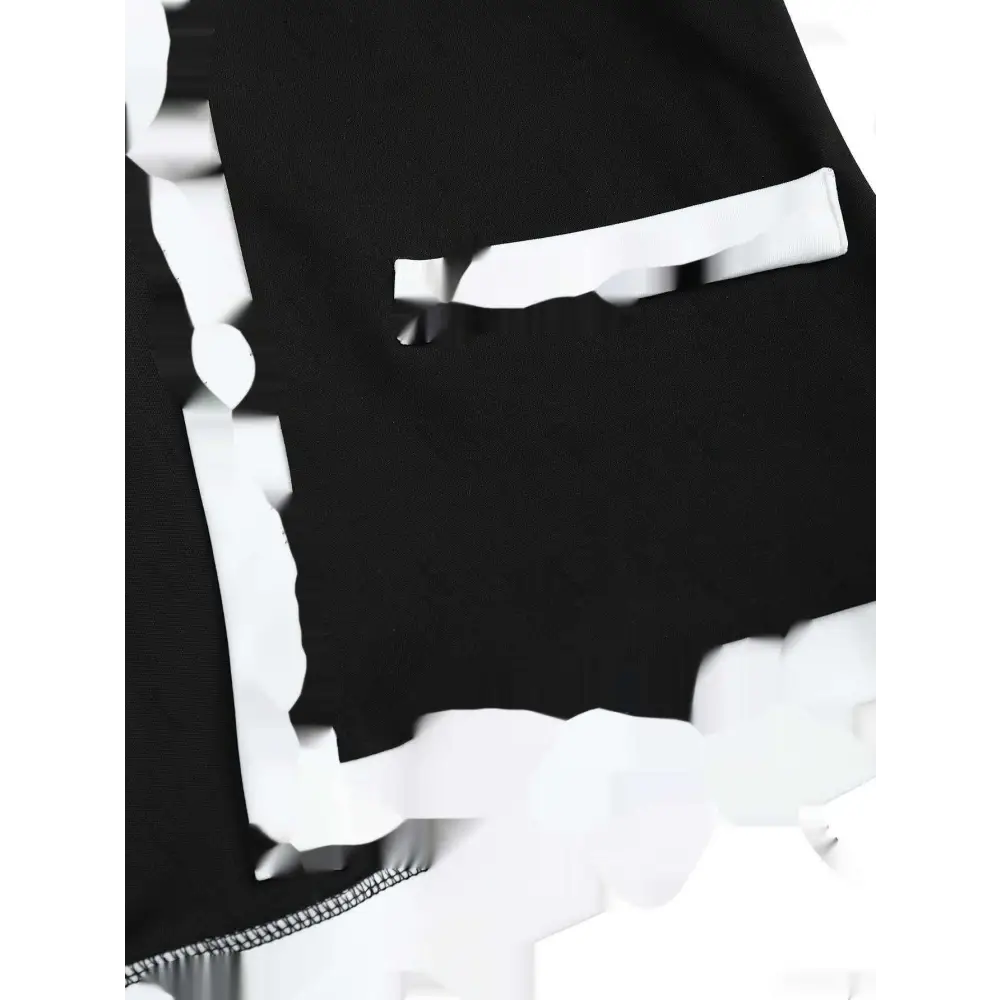 Black fabric shorts with white ruffled trim as part of a women’s matching blazer and hip skirt set with black sleeveless style