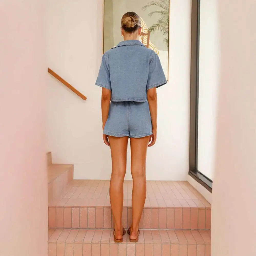 Women’s irregular denim short pantskirt suit in light-wash cotton featuring a cropped short-sleeved jacket and matching shorts
