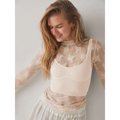 A delicate cream-colored long-sleeved women’s see-through lace floral mesh top with ribbed bodice and high neckline