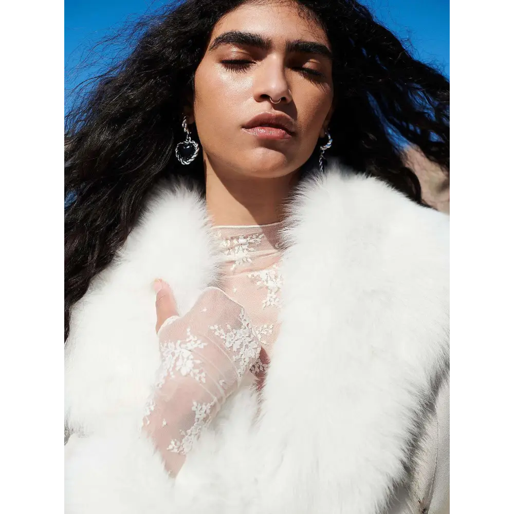White faux fur coat with plush texture paired with long-sleeved women’s see-through lace floral mesh top and high neckline