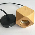 Minimalist hexagonal wood pendant light with natural finish and black metal base featuring edison glass bulb for living room