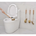 Wooden household handle cleaning toilet brush with natural bristles shown in use near a white ceramic toilet