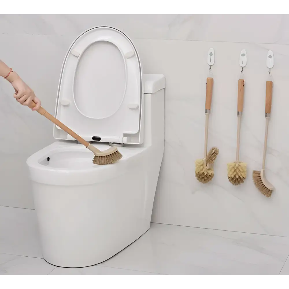 Wooden household handle cleaning toilet brush with natural bristles shown in use near a white ceramic toilet
