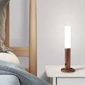 A sleek wooden led desk lamp sconce with frosted glass cylindrical white led light and natural wood base
