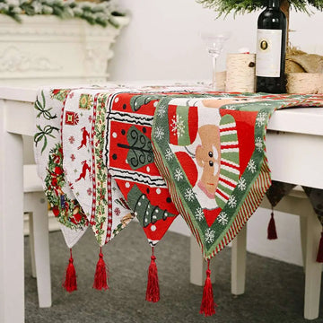 Woven christmas table runner in red green and white with festive patterns and matching red tassels for holiday decor