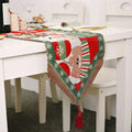 Red and green woven christmas table runner with festive reindeer, snowflakes, stripes, and red tassels for holiday decor