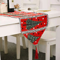 Woven christmas table runner in red with green christmas tree patterns, black-and-white polka dots, and tassels