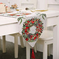 Woven Christmas table runner in red and green with festive embroidery and matching tassels for holiday decor