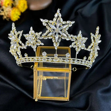 A sparkling gold xingx rhinestone fashion tiara crown with intricate crystal star and floral designs in metal framework