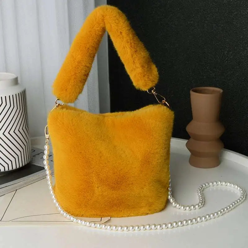 Vibrant yellow checkerboard plush bucket bag with plush faux fur handle and elegant pearl chain design strap