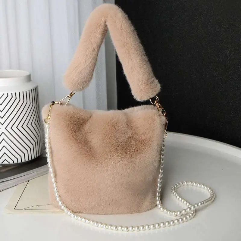 Soft blush-colored faux fur plush bucket bag with fluffy handle and pearl chain design for stylish use