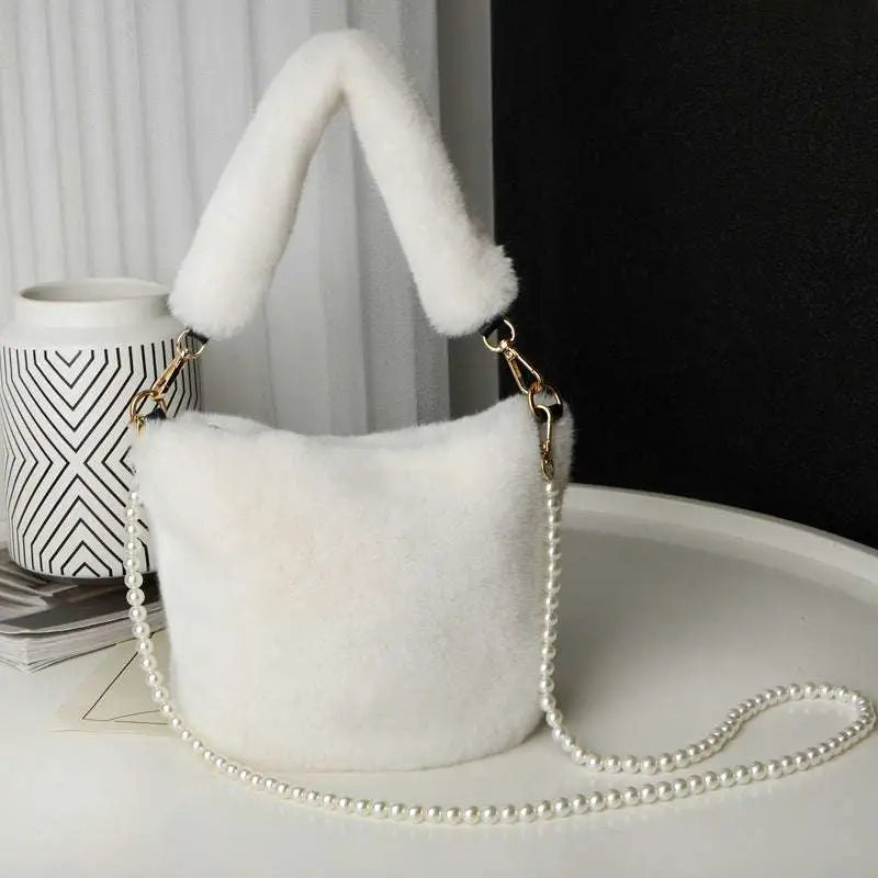 White faux fur handbag with fluffy handle and pearl chain design resembling a yellow checkerboard plush bucket bag