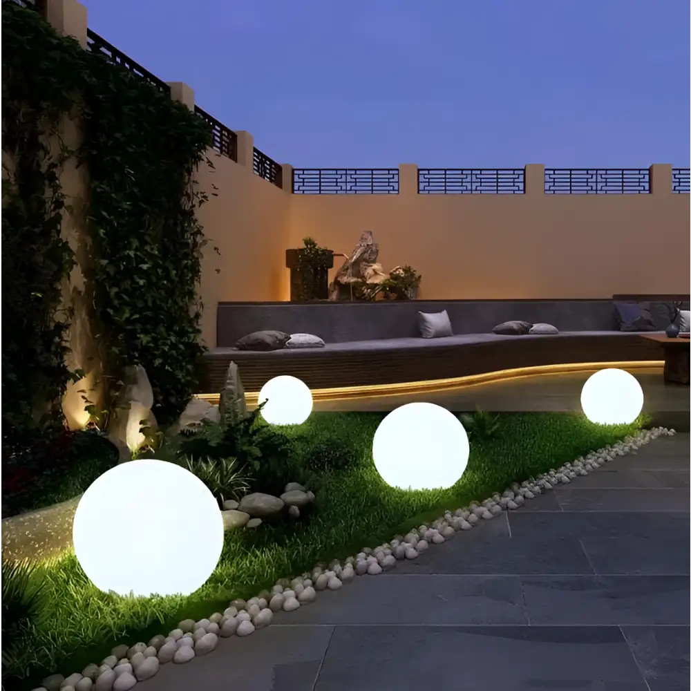 Yellow glowing spherical outdoor lights with smooth translucent surface softly illuminating garden spaces