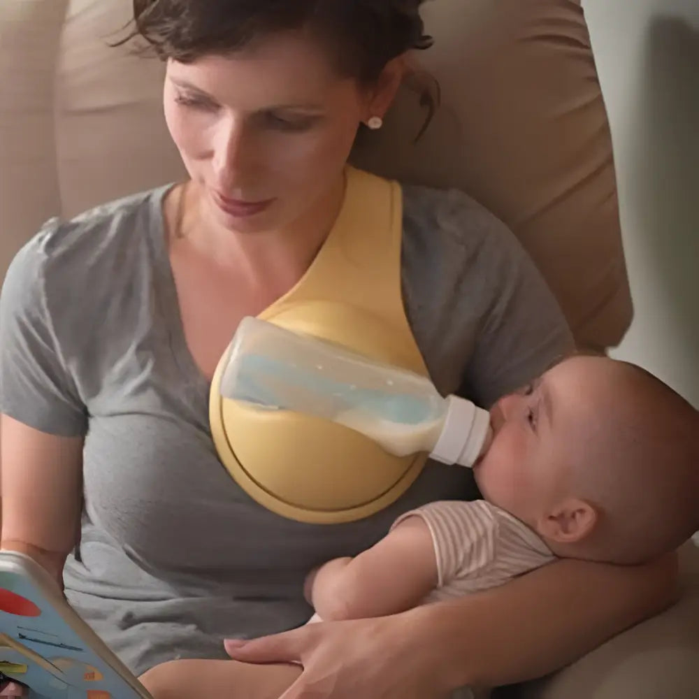 Yellow hands free baby bottle holder with clear plastic bottle attached for convenient hands free feeding