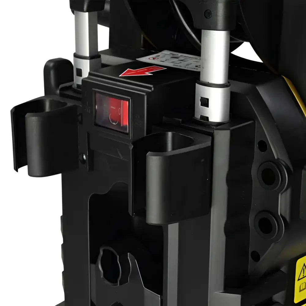 Black plastic power tool with red illuminated switch and silver accents attached to yellow pressure cleaning machine with retractable hose reel