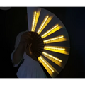 A yellow led folding fan with glowing lights held open against a dark background for fan dancing lights performances