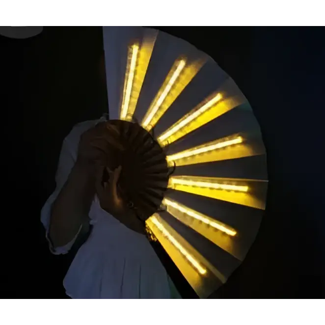 A yellow led folding fan with glowing lights held open against a dark background for fan dancing lights performances