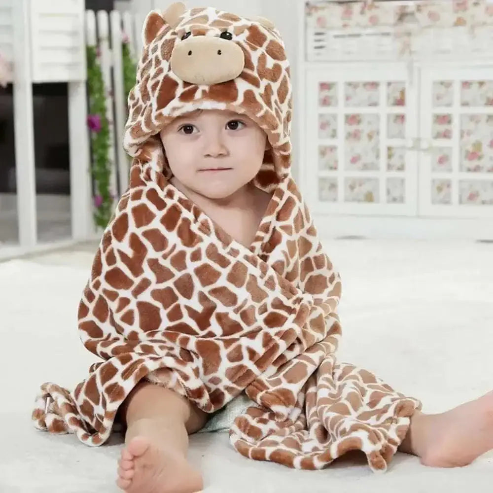 A plush animal baby towel blanket featuring a brown and cream giraffe pattern with a soft hood and cute face