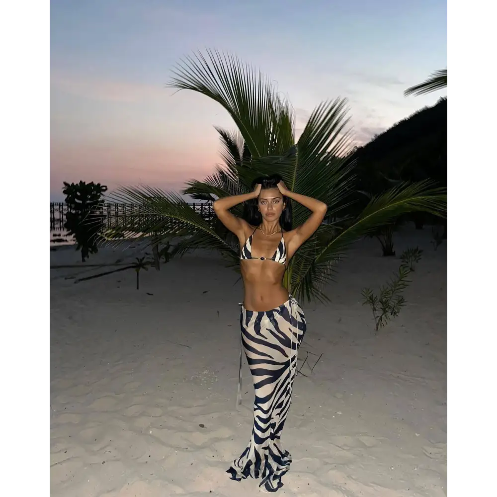 A black and white zebra printed bikini with a strappy triangle top and high-waisted flowing pants casual suit