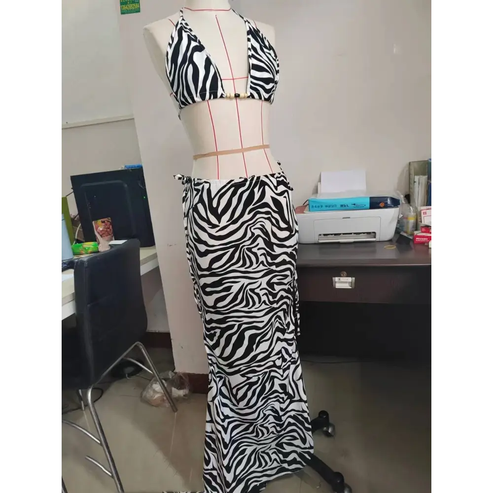A black and white zebra printed bikini strappy skirt casual suit displayed on a mannequin in a two-piece set