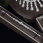 A sparkling silver bracelet with clear zircon stones displayed in a black velvet box from a bracelet ring set