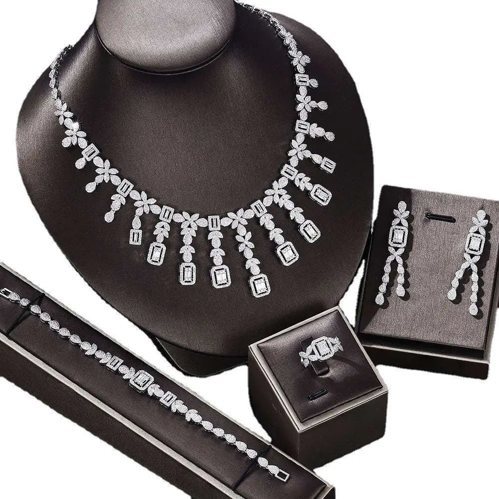 Silver zircon necklace with floral design featuring rectangular and round-cut stones displayed on black mannequin bust